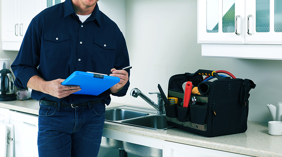 home inspector leaning by kitchen sink